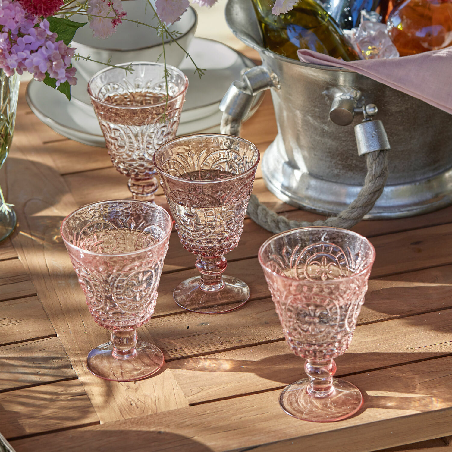 Set di 4 bicchieri da vino Sarton Set di quattro bicchieri rosa in vetro lavorato su tavolo in legno, decorazione elegante