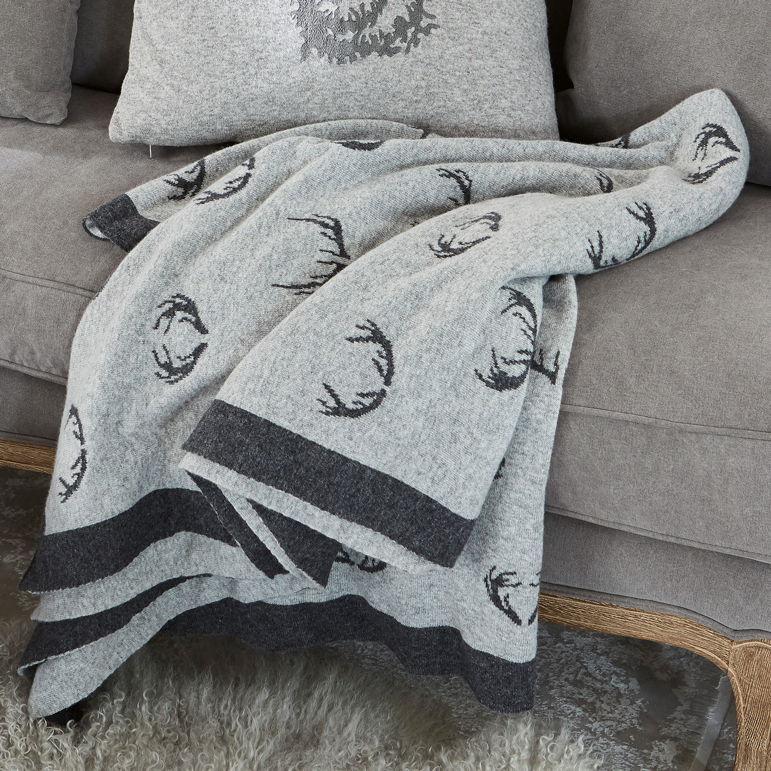 Plaid double face Lodge Coperta in lana grigia con motivo corna nere su divano grigio, decorazione e comfort casa