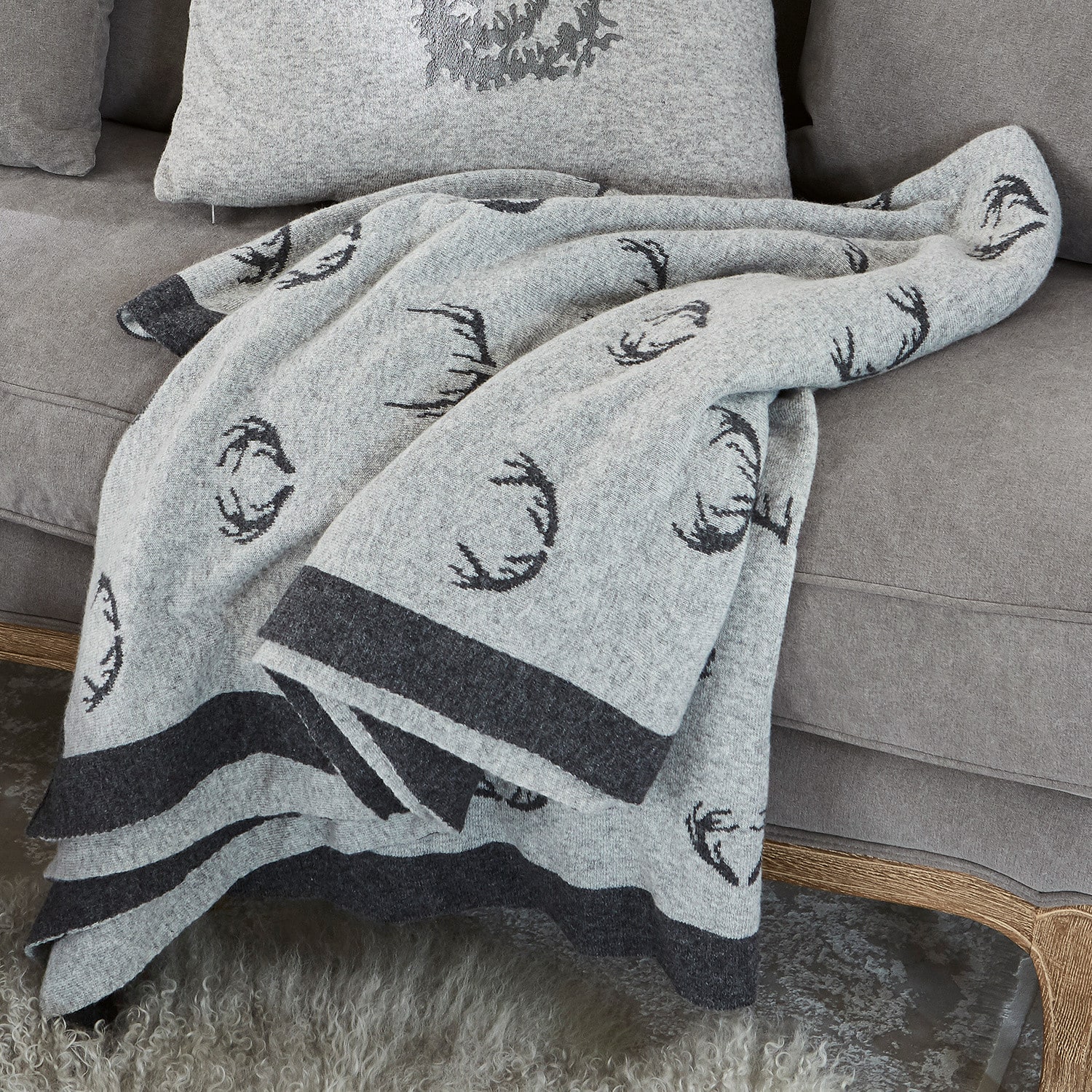 Plaid double face Lodge Coperta in lana grigia con motivo corna nere su divano grigio, decorazione e comfort casa