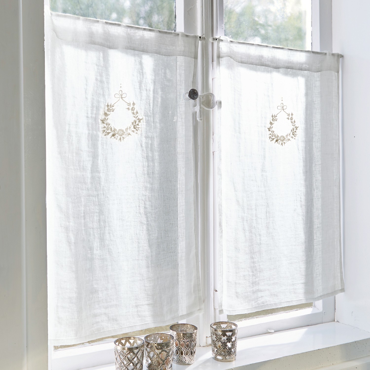 Tendina a vetro Bréteny Tende bianche in lino con delicato ricamo e portacandele decorativi sul davanzale
