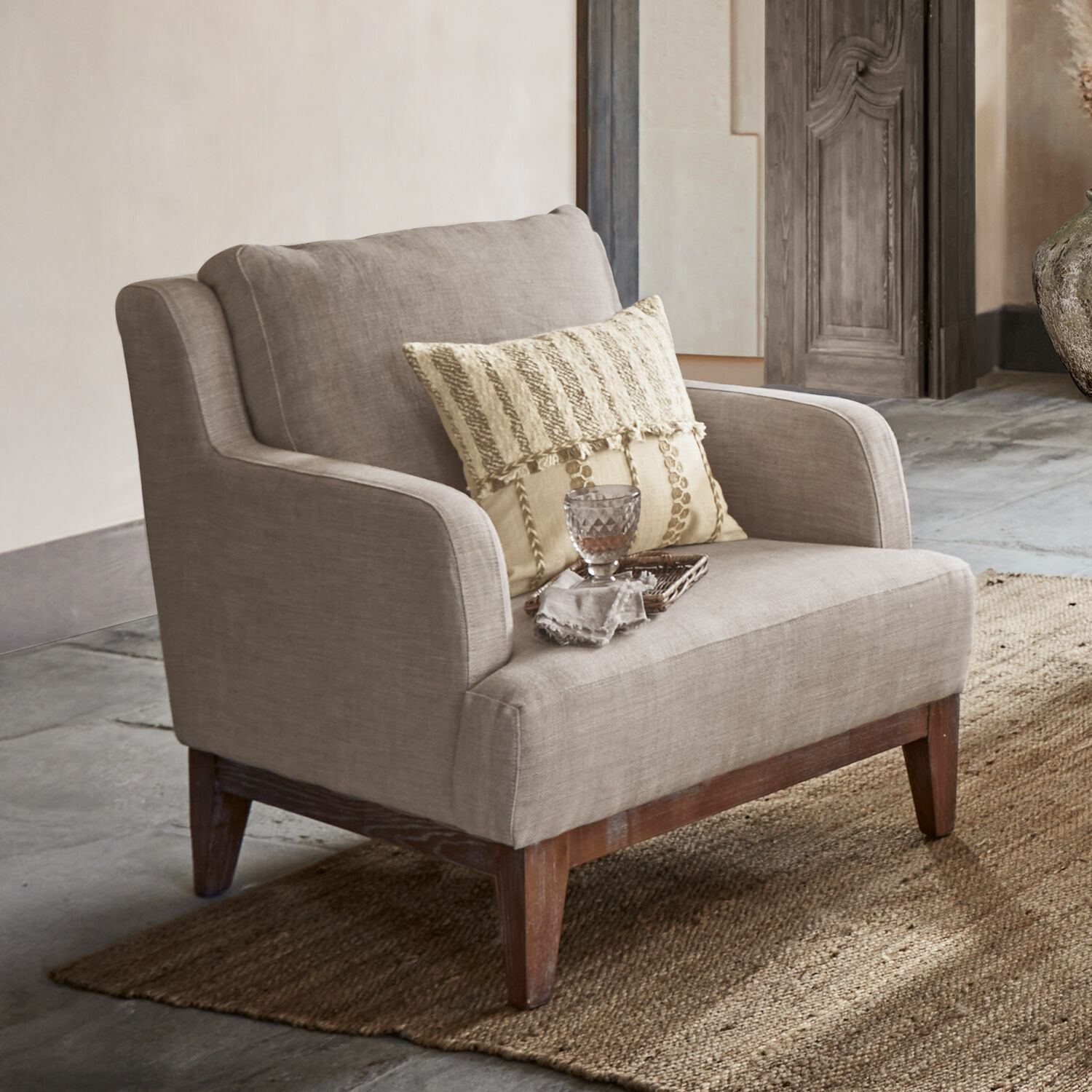 Poltrona Saunders Poltrona beige in tessuto con gambe in legno su tappeto, mobile elegante per soggiorno