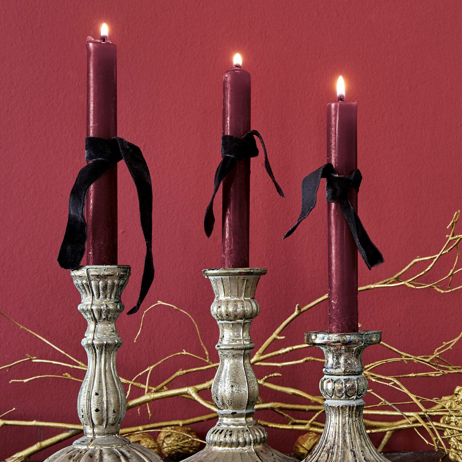 Set di 12 candele Bauceau Tre candelabri in metallo argentato con candele bordeaux e nastri neri su sfondo rosso