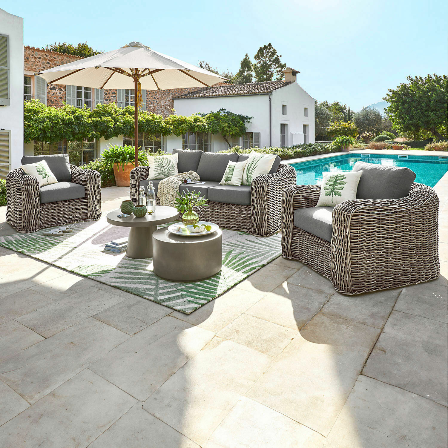 Set divano e poltrone Upminster Set di mobili da giardino in tecnorattan grigio con cuscini e ombrellone vicino alla piscina