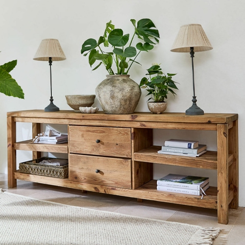 Consolle in legno con cassetti e ripiani, decorata con lampade e piante, stile naturale