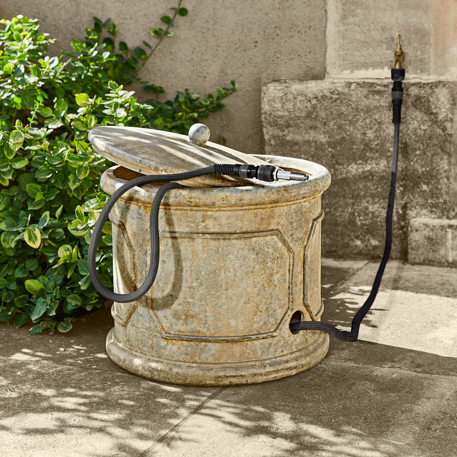 Cesto portatubo da giardino Filervo Contenitore da giardino rotondo in pietra beige con tubo nero per irrigazione