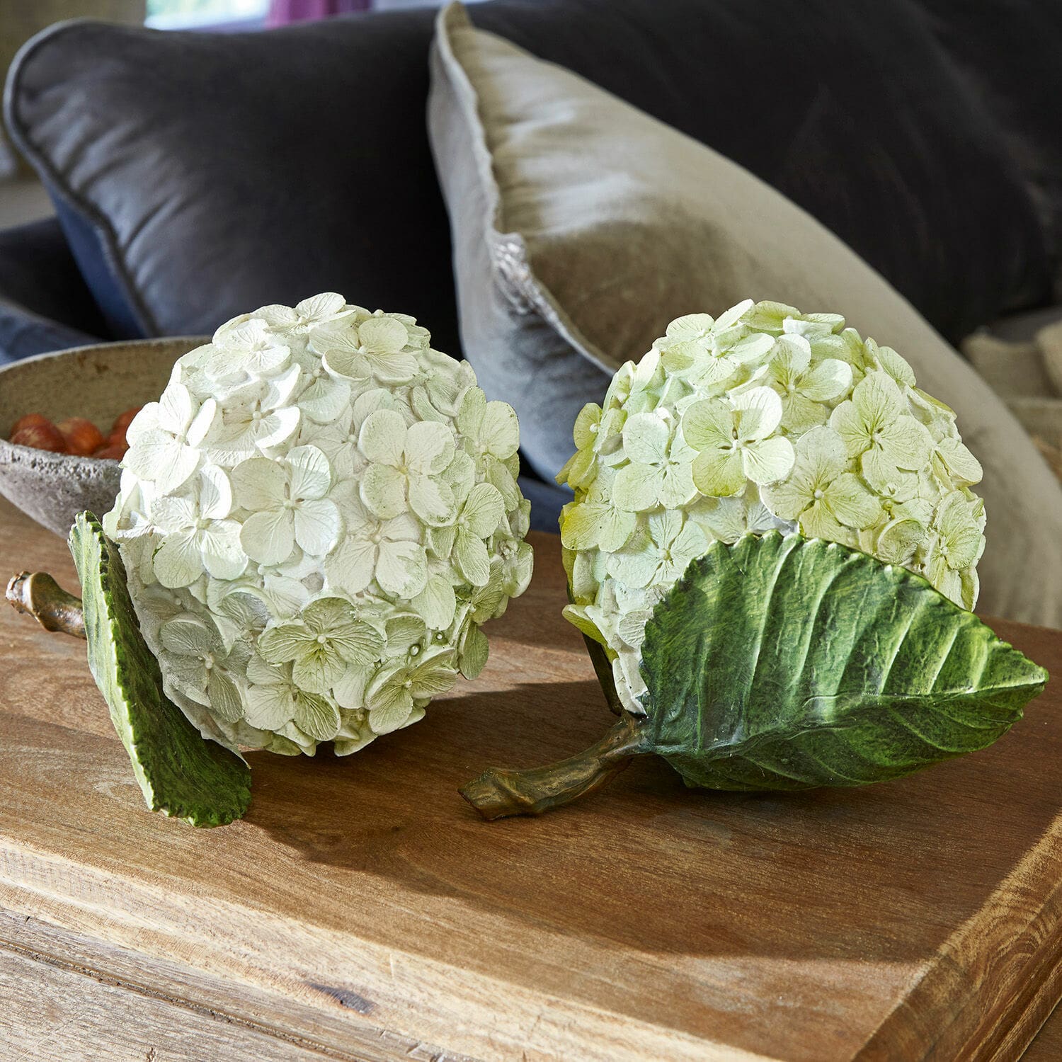 Coppia di fiori decorativi Hortensie Sfere decorative floreali in materiale color crema e verde chiaro su tavolo in legno