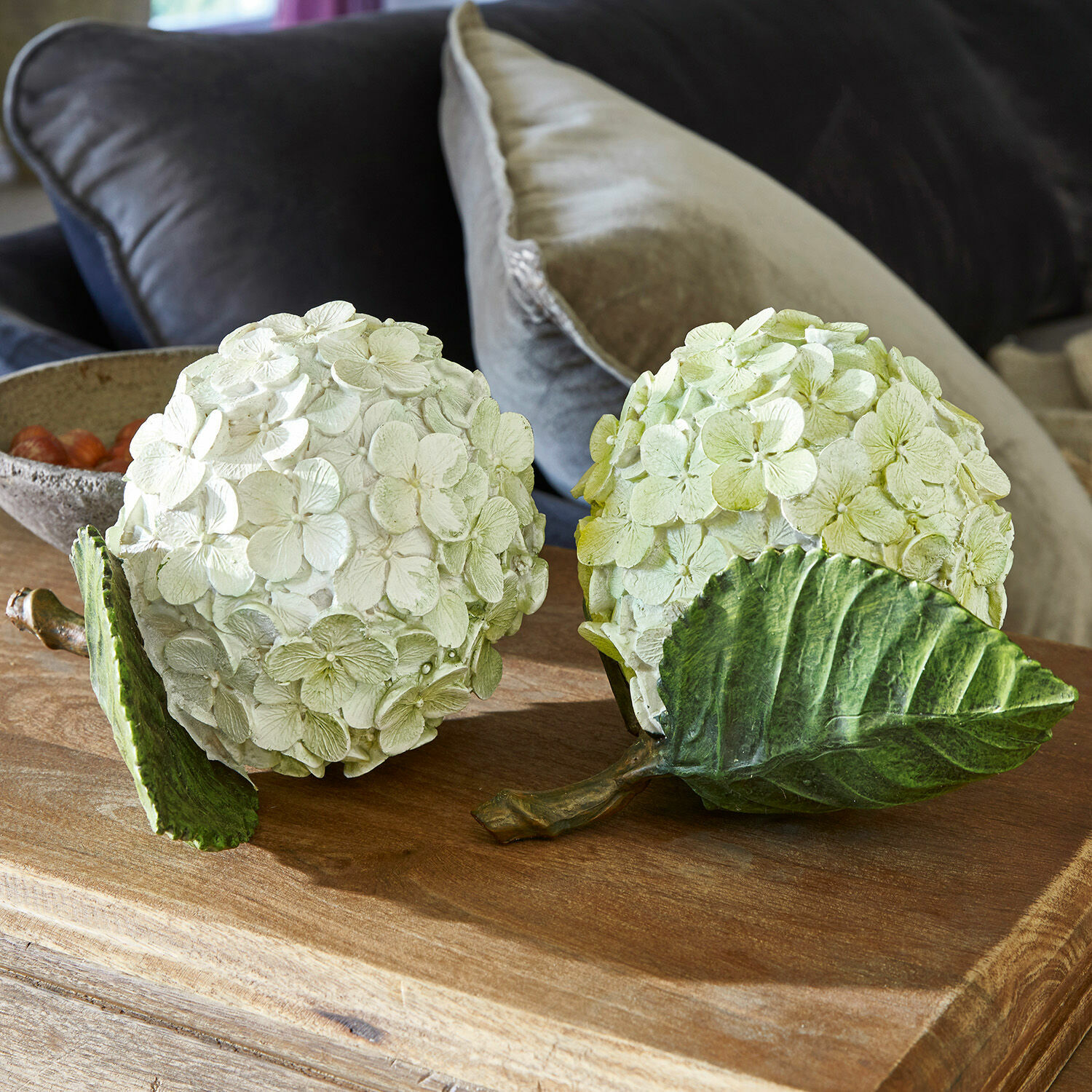 Coppia di fiori decorativi Hortensie Sfere decorative floreali in materiale color crema e verde chiaro su tavolo in legno
