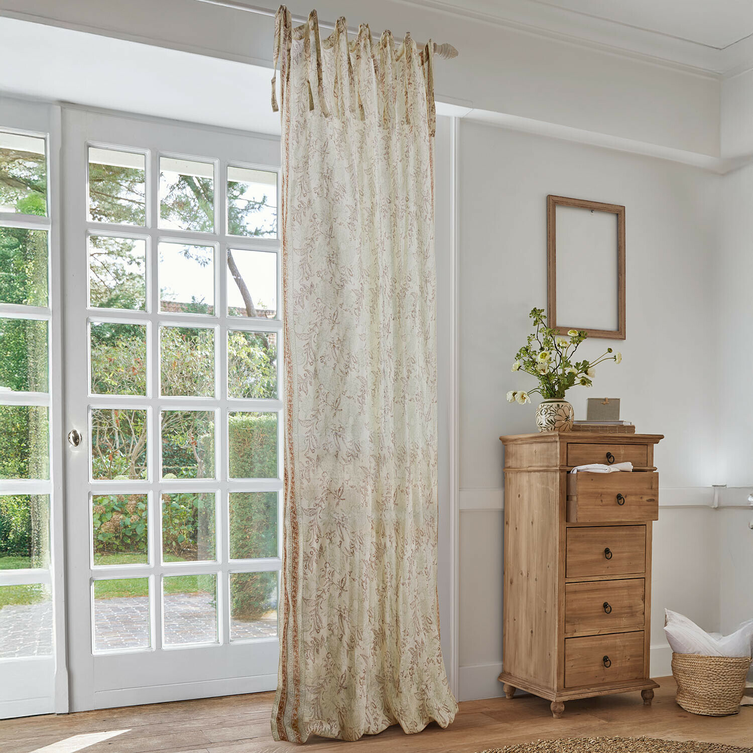 Tendina Floréane Tenda beige con delicato motivo floreale in soggiorno luminoso con cassettiera in legno e grande finestra