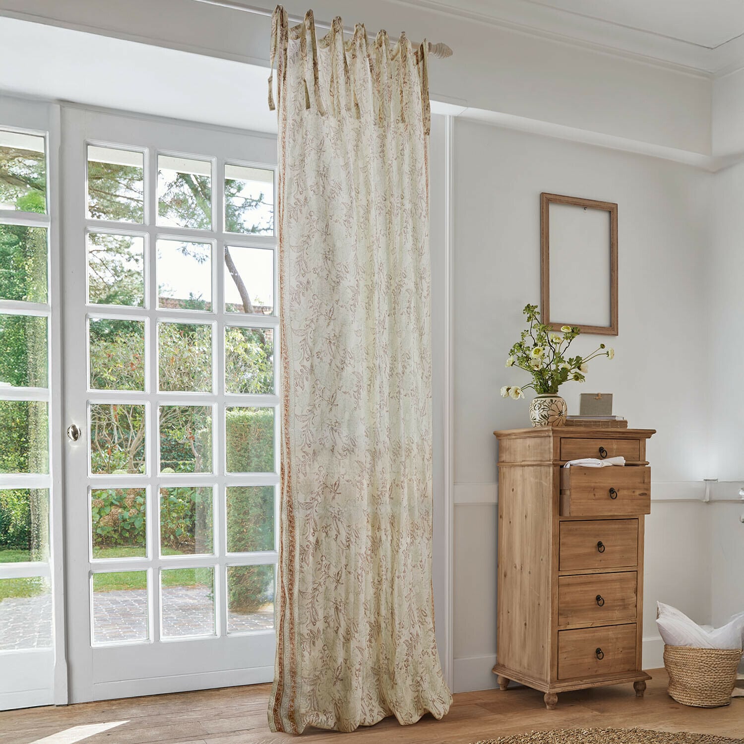 Tendina Floréane Tenda beige con delicato motivo floreale in soggiorno luminoso con cassettiera in legno e grande finestra