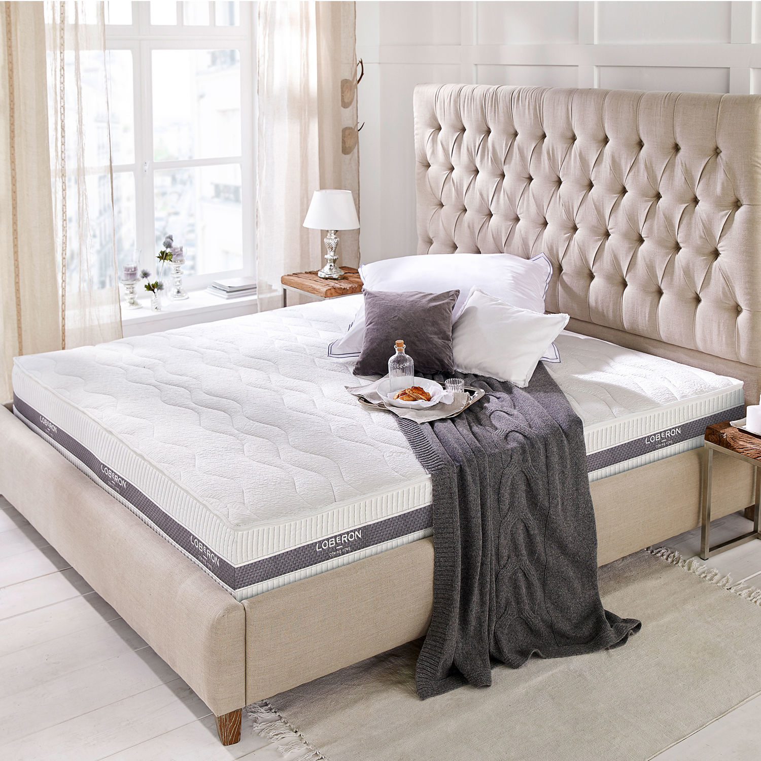 Materasso 180x200 Turim Materasso bianco moderno Loberon su letto beige con testiera capitonné in camera luminosa