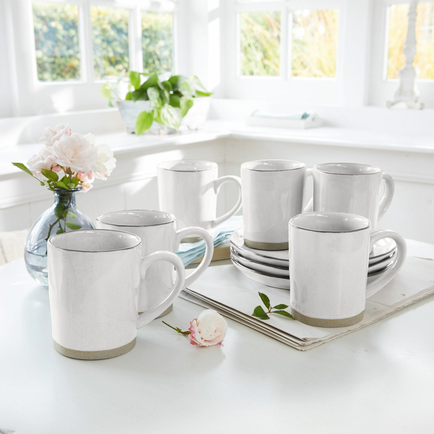 Set di 6 tazze Biarré Set di sei tazze in ceramica bianca con bordo grigio su tavolo chiaro in interno luminoso