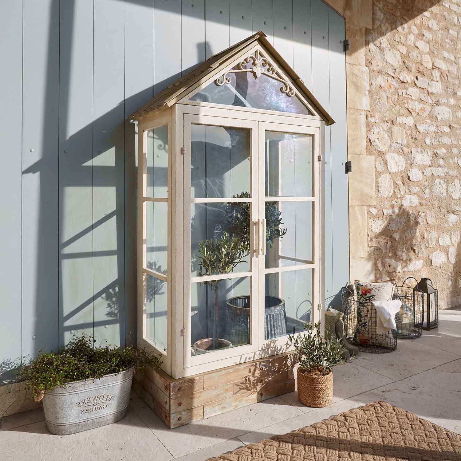 Piccola serra da giardino in metallo e vetro color crema con piante, decorazione terrazza