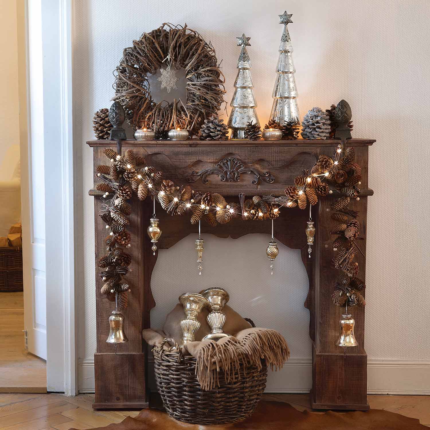Camino rustico in legno decorato con pigne, luci e ornamenti natalizi argentati