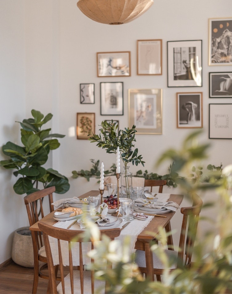 Sala da pranzo con tavolo e sedie in legno, decorazioni verdi e candele, stile naturale d'interni
