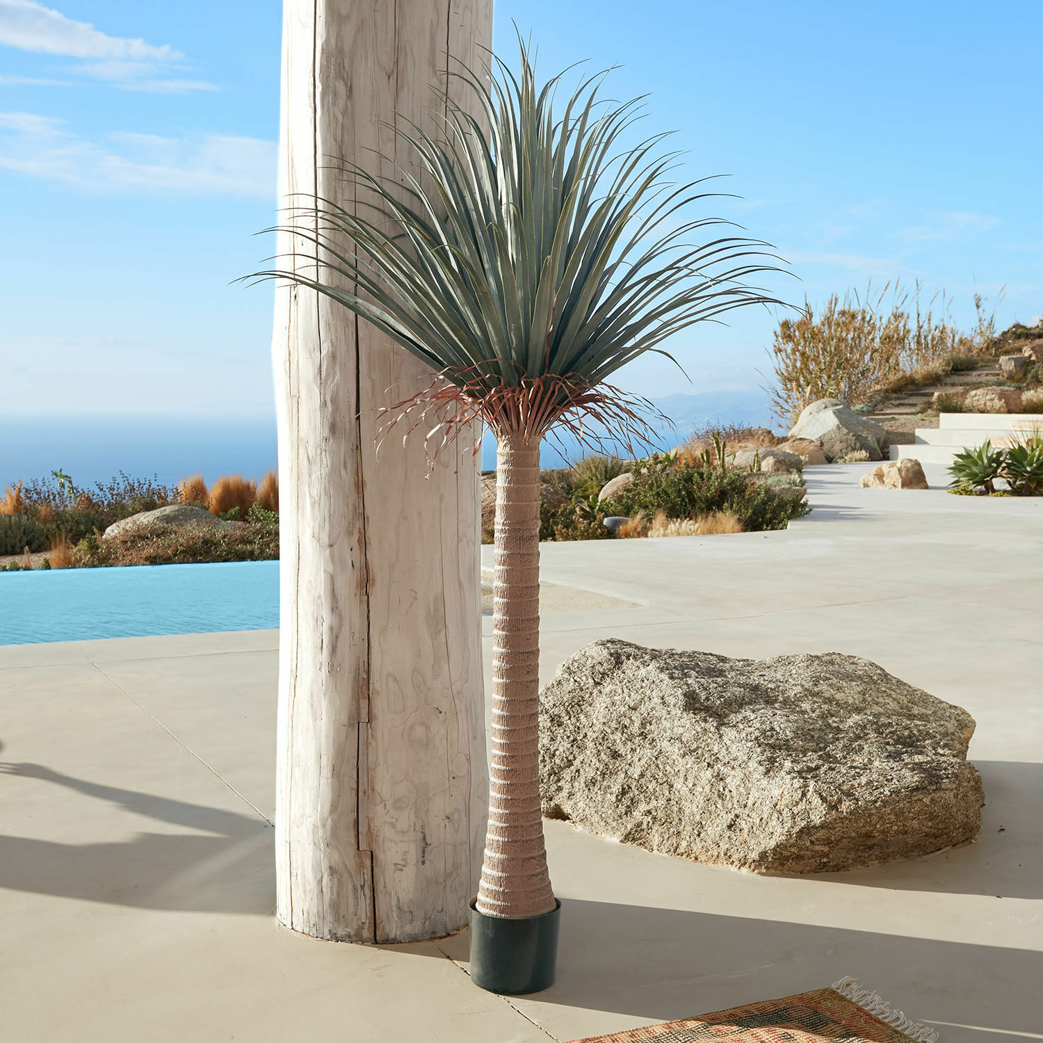 Palma decorativa Remivon Palma artificiale in vaso con tronco marrone e foglie verdi su terrazza con vista mare
