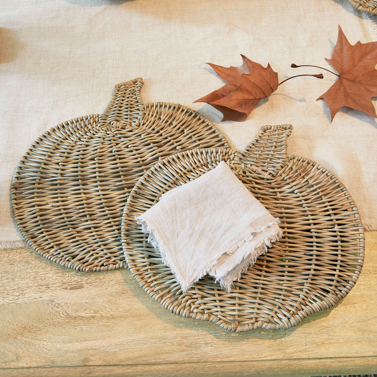 Coppia di tovagliette Larivonne Due tovagliette in vimini a forma di zucca colore naturale con tovagliolo di lino e foglie autunnali