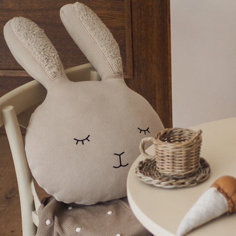 Cuscino beige a forma di coniglio in tessuto morbido con ricami su orecchie e volto per bambini