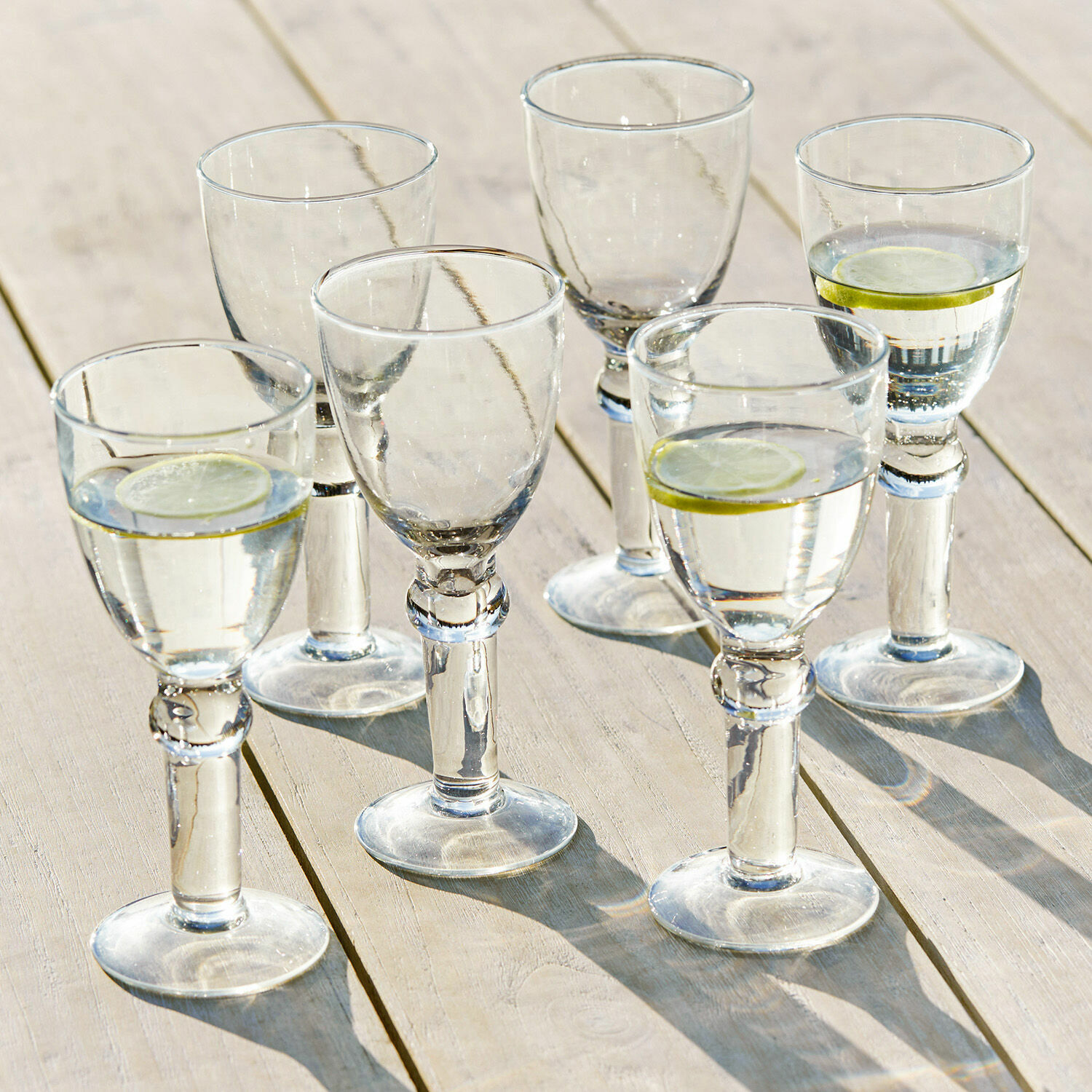 Set di 6 bicchieri da vino Devon Set di sei bicchieri trasparenti con acqua e fette di limone su tavolo di legno chiaro