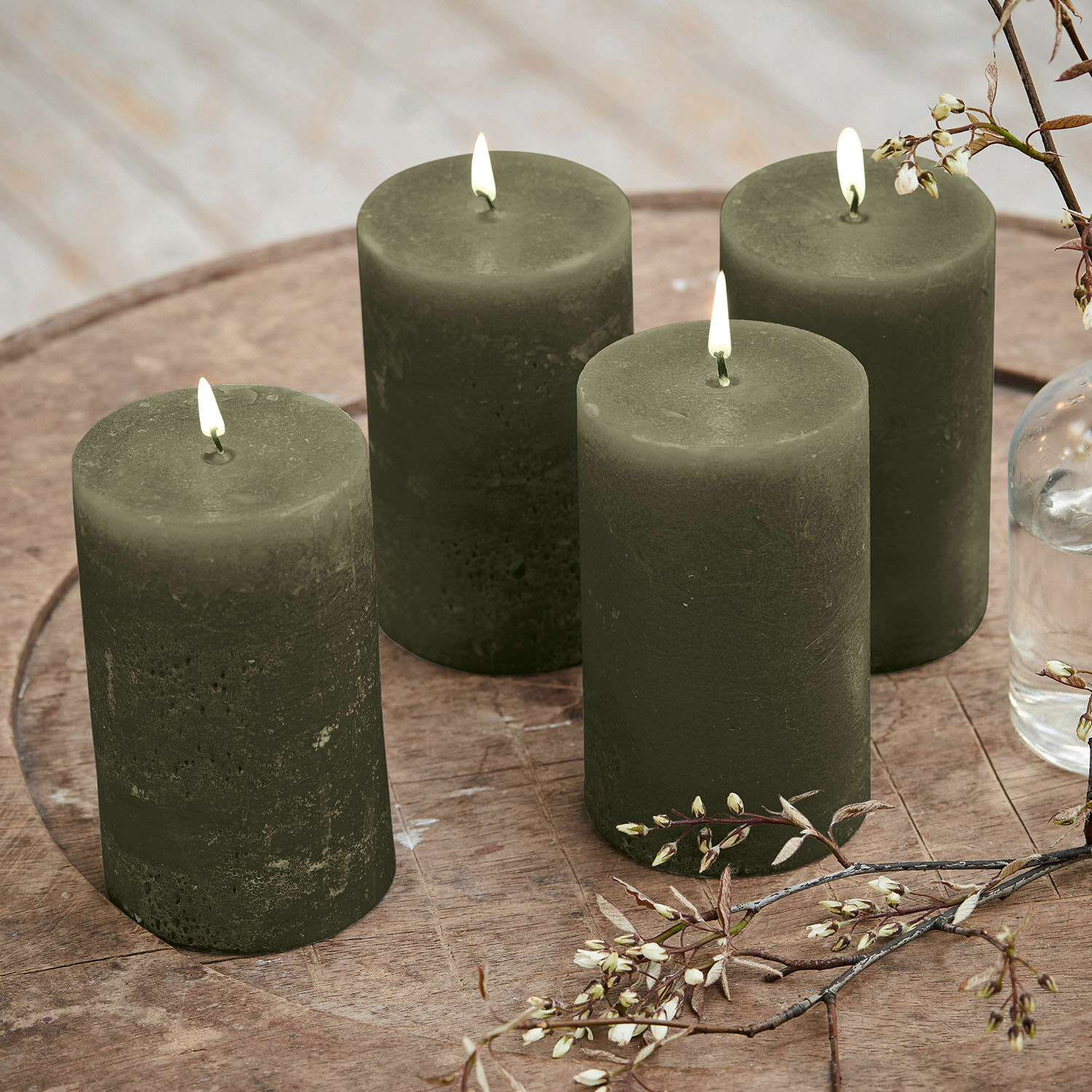 Set di 4 candele Braga Set di quattro candele verdi in cera su tavolo di legno con decorazione floreale