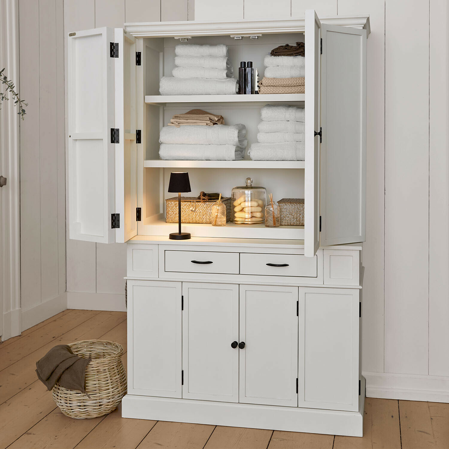 Mobile alto Lydia Mobile in legno bianco con ante aperte, asciugamani bianchi e decorazioni, arredo bagno