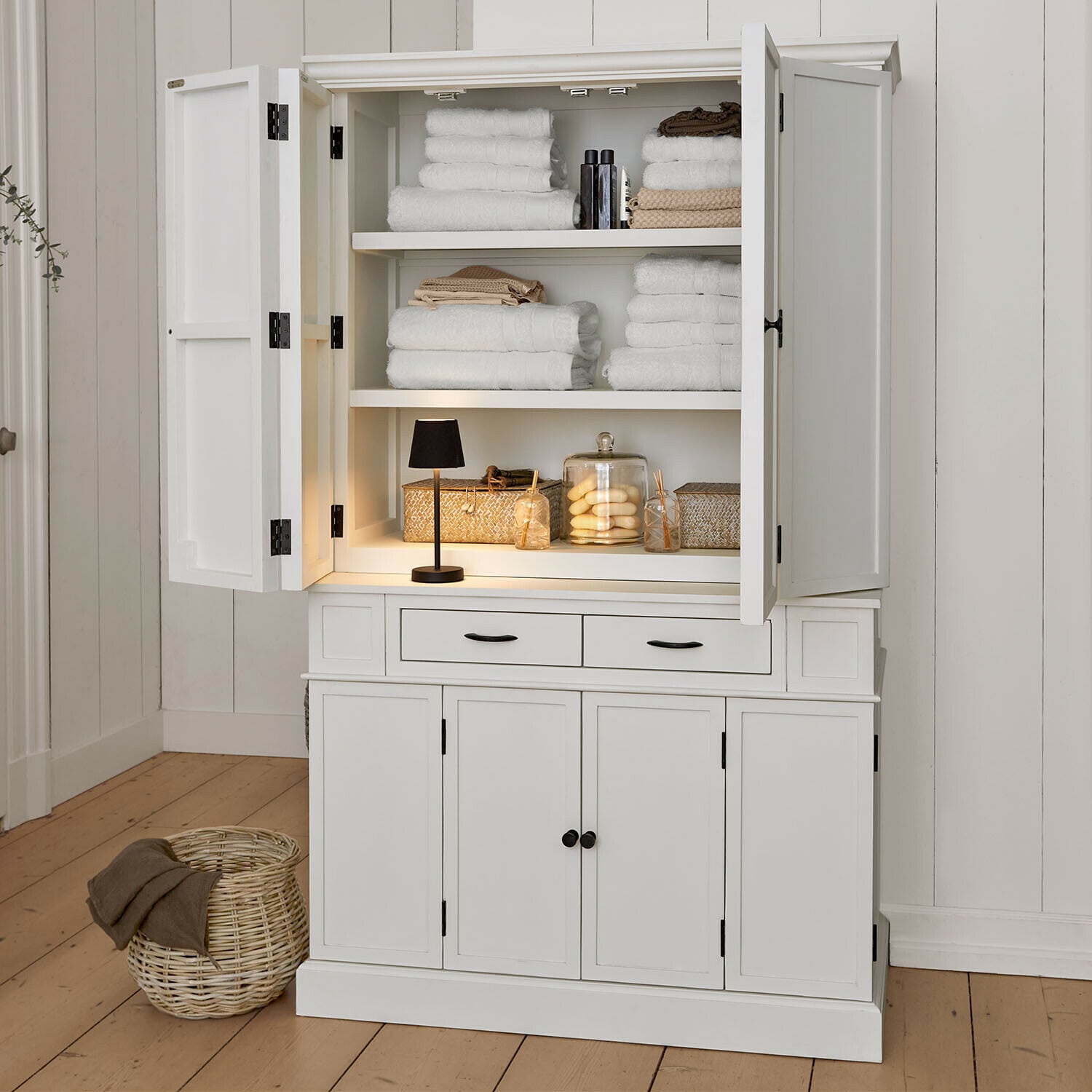 Mobile alto Lydia Mobile in legno bianco con ante aperte, asciugamani bianchi e decorazioni, arredo bagno