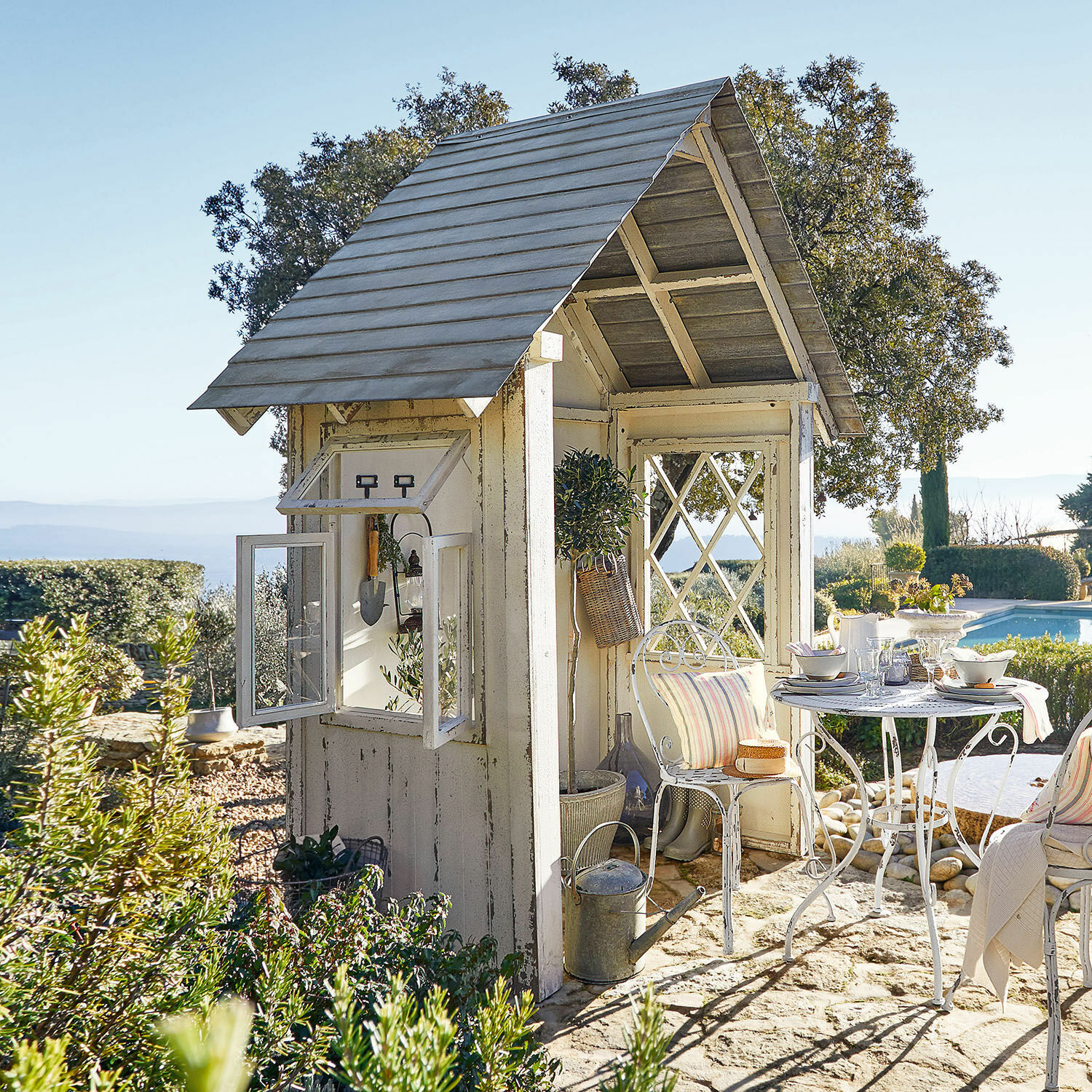 Casetta da giardino Sumter Gazebo da giardino in legno bianco con tavolo e sedie in metallo su pavimento in pietra vicino alla piscina