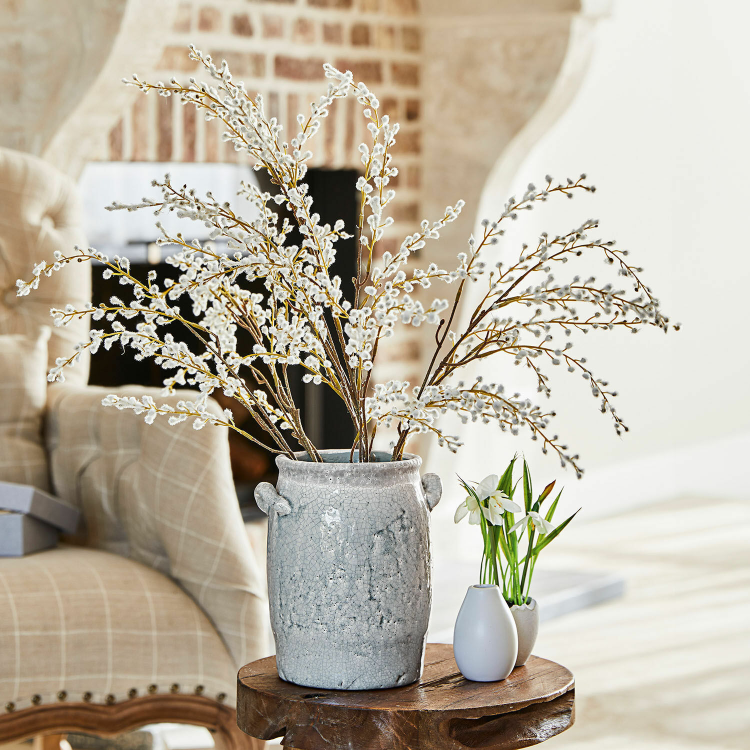 Set di 3 rami decorativi Palmyra Vaso in ceramica grigia con rami di salice su tavolo in legno in soggiorno luminoso