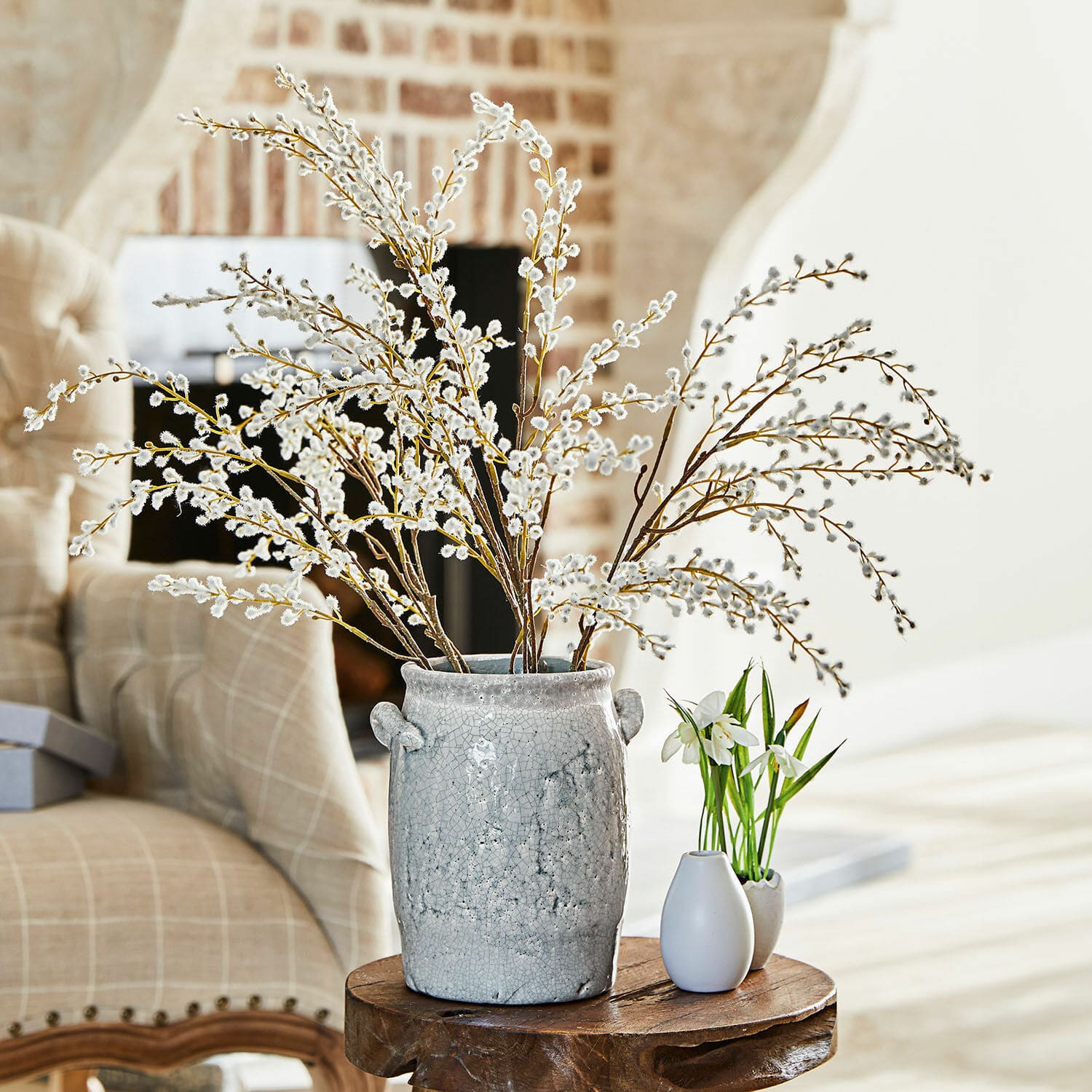 Set di 3 rami decorativi Palmyra Vaso in ceramica grigia con rami di salice su tavolo in legno in soggiorno luminoso