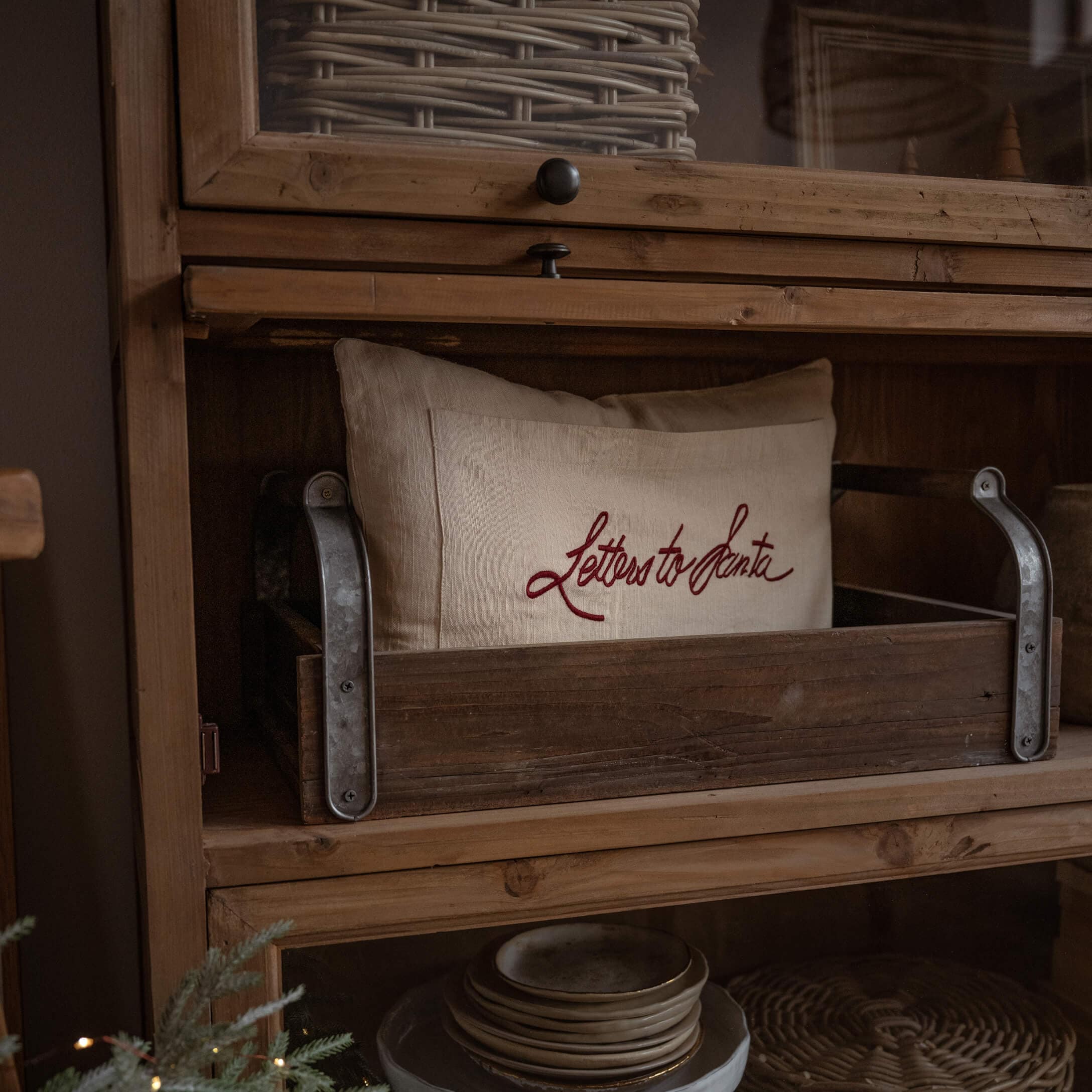 Cuscino in lino beige con scritta rossa Letters to Santa in cassetta di legno su mensola