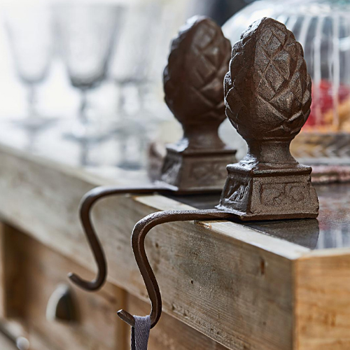 Ganci decorativi in ferro marrone con motivo pigna su piano di legno