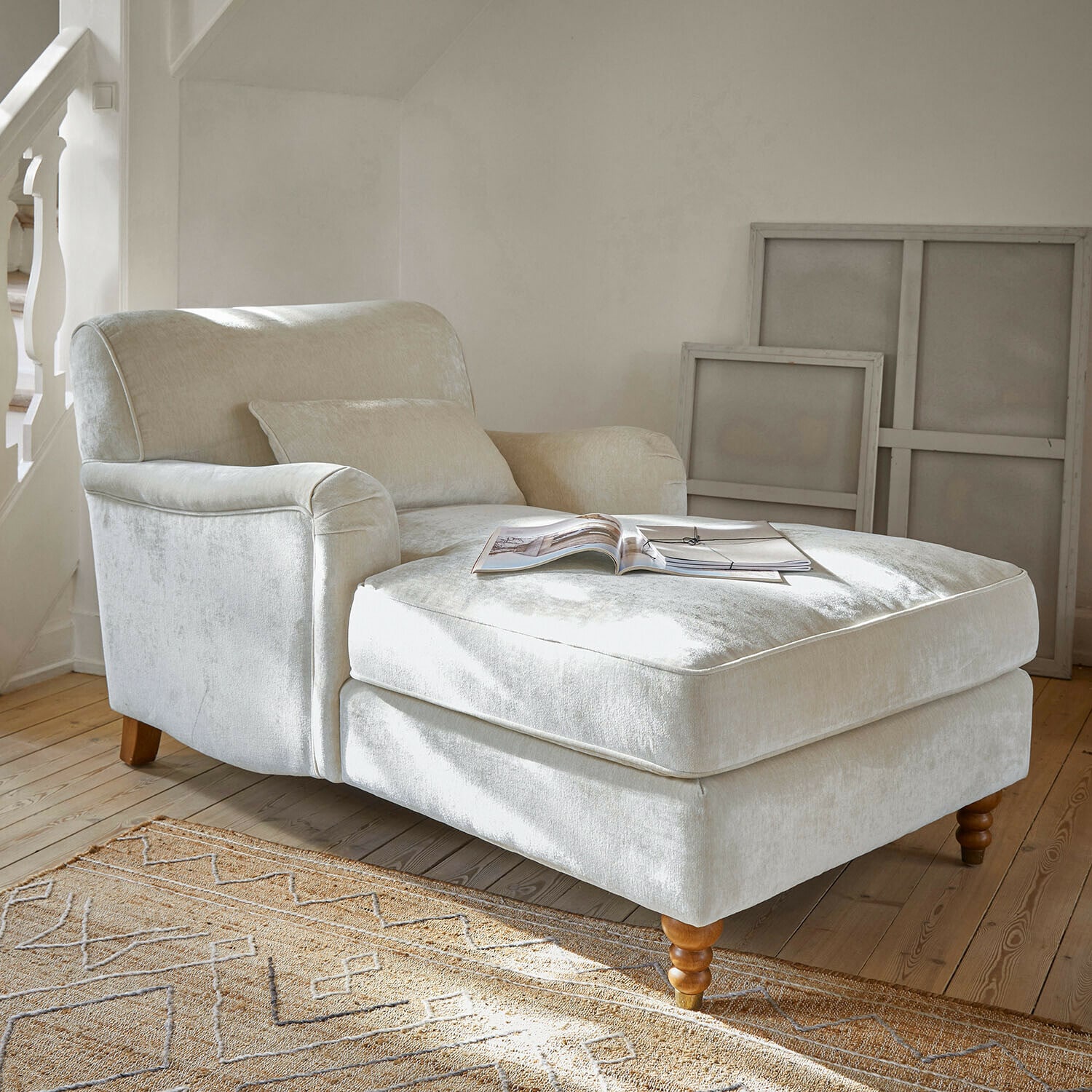 Chaise longue Isa Poltrona beige in tessuto morbido con poggiapiedi e gambe in legno in soggiorno luminoso