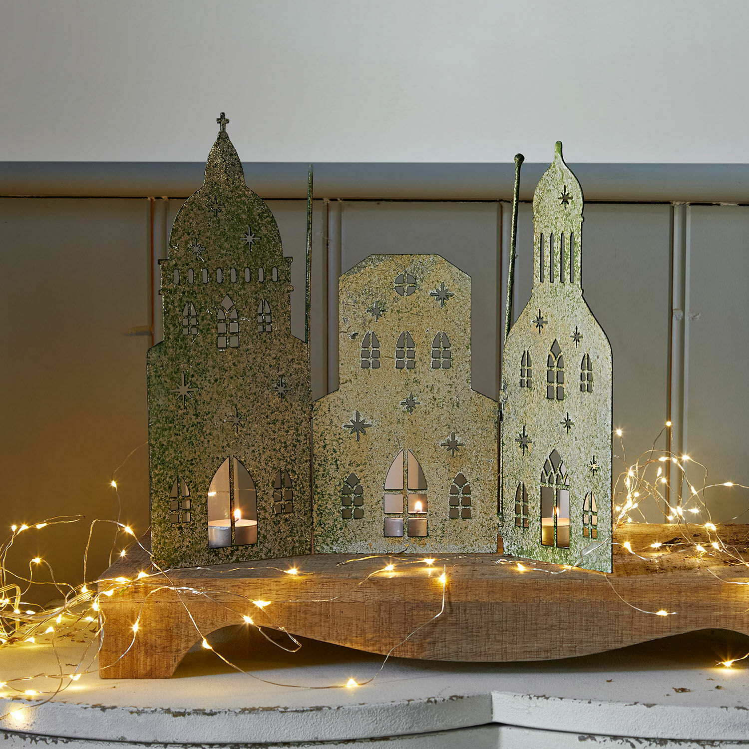 Paravento decorativo Roskilde Decorazione in metallo con tre edifici e candele, colore verde dorato, ornamento natalizio LED per atmosfera accogliente