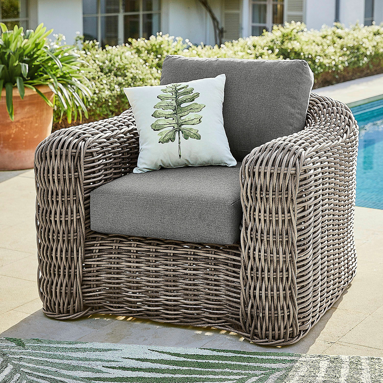 Poltrona Upminster Poltrona da giardino in rattan grigio con cuscini grigi e cuscino decorativo con foglia verde
