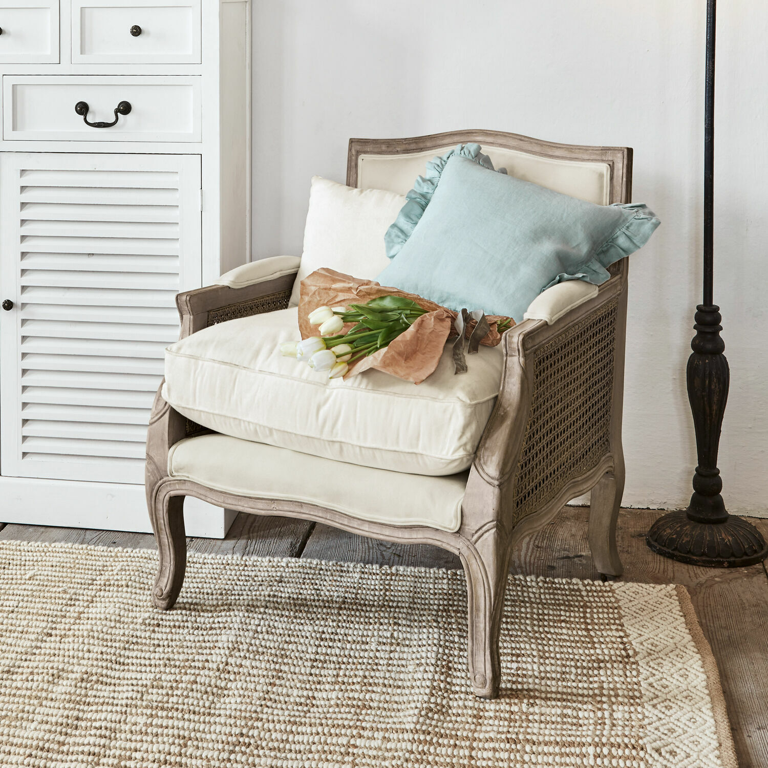 Poltrona Alfort Poltrona classica in legno e tessuto crema con cuscini e mazzo di tulipani bianchi