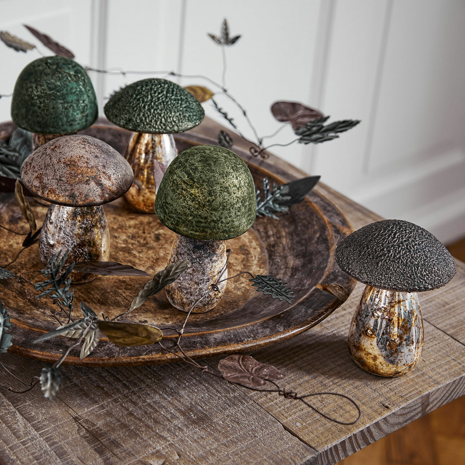 Set di 5 funghi decorativi Grana Funghi decorativi in metallo verde e marrone su tavolo in legno con vassoio rustico