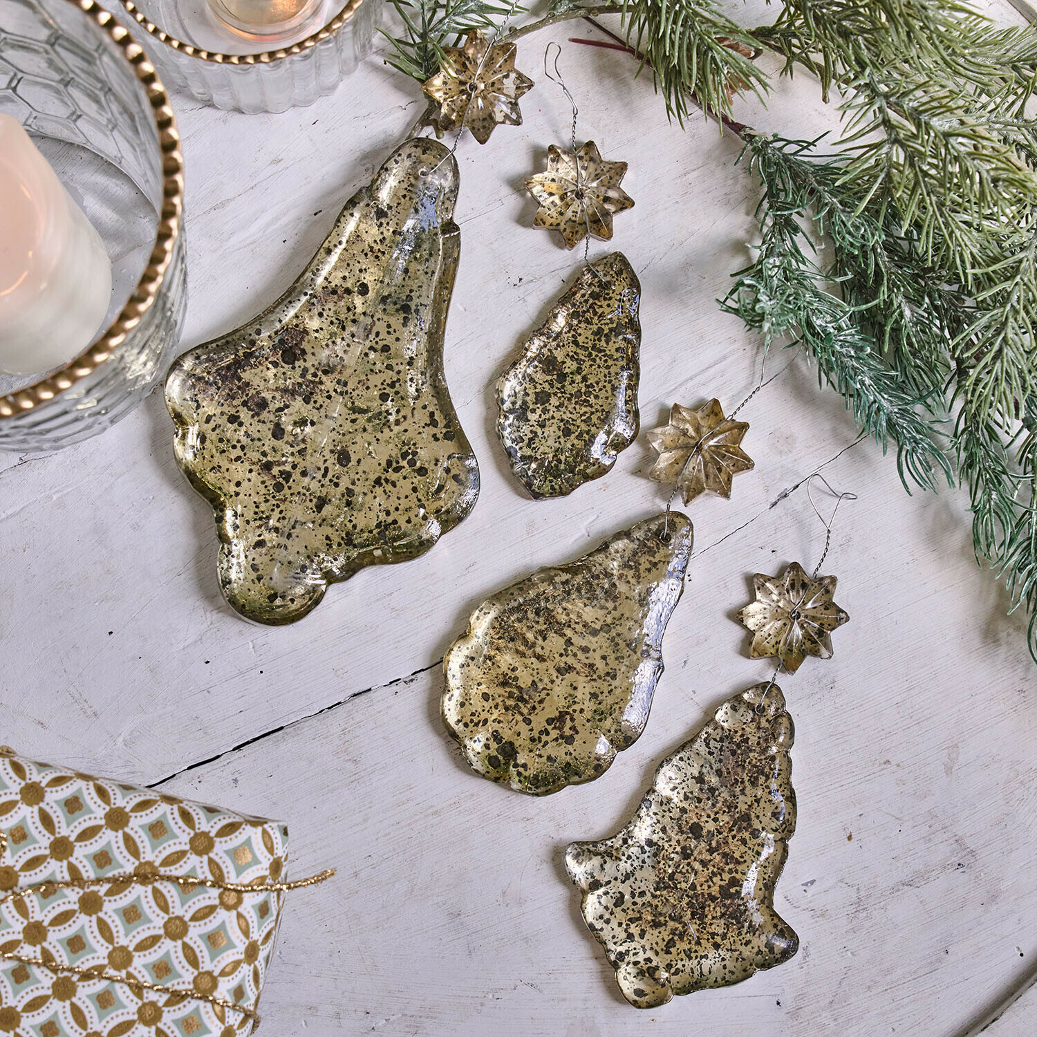 Set di 4 decorazioni natalizie Dolenza Set di decorazioni natalizie in metallo dorato a forma di campane e stelle su sfondo bianco