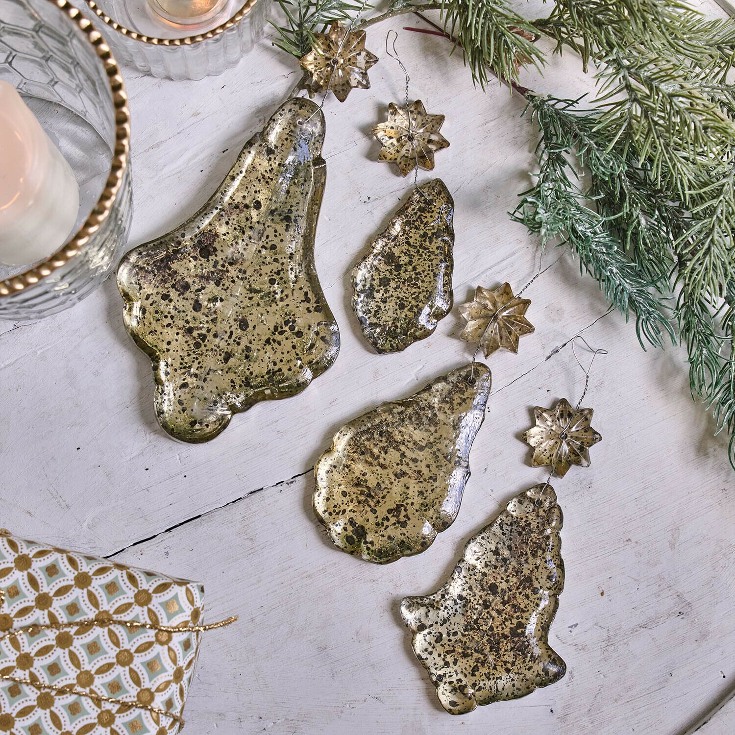 Set di 4 decorazioni natalizie Dolenza Set di decorazioni natalizie in metallo dorato a forma di campane e stelle su sfondo bianco