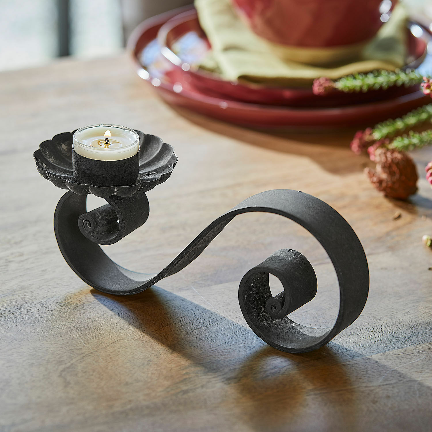 Set di 4 portacandele Vorelin Portacandela in metallo nero con spirale decorativa e candela bianca su tavolo in legno