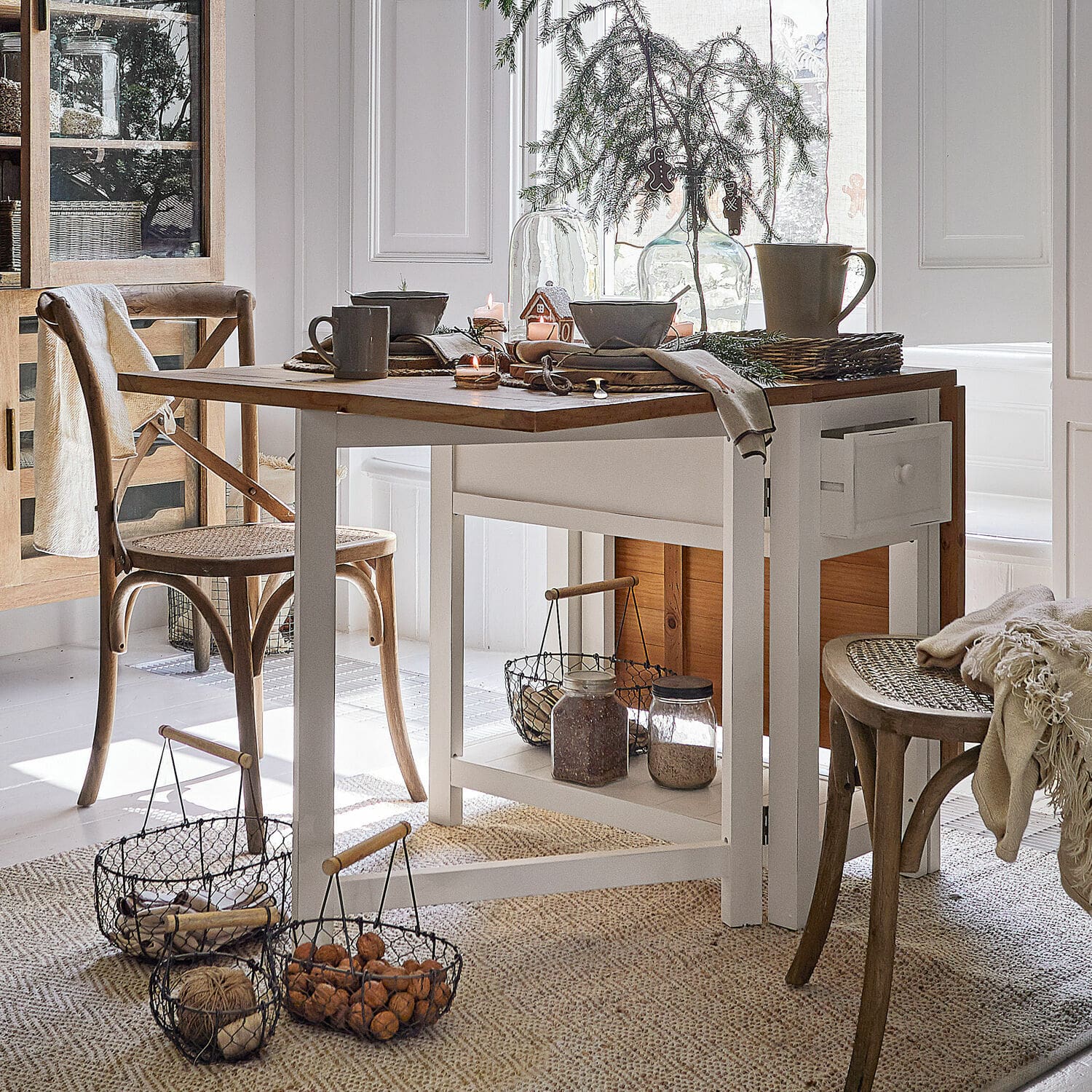 Tavolo Dale Sala da pranzo con tavolo in legno bianco e sedie in vimini naturale, decorazioni natalizie e cesti con noci