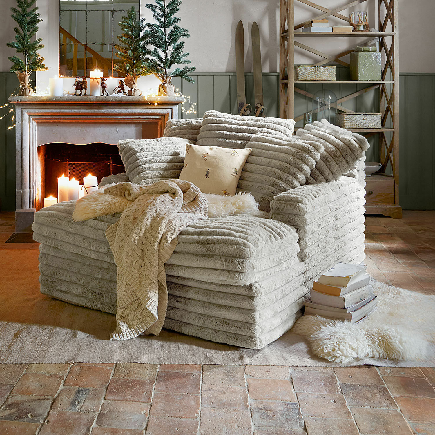 Chaise-longue Woodminster Poltrona accogliente in tessuto beige morbido in soggiorno rustico con camino e decorazioni natalizie