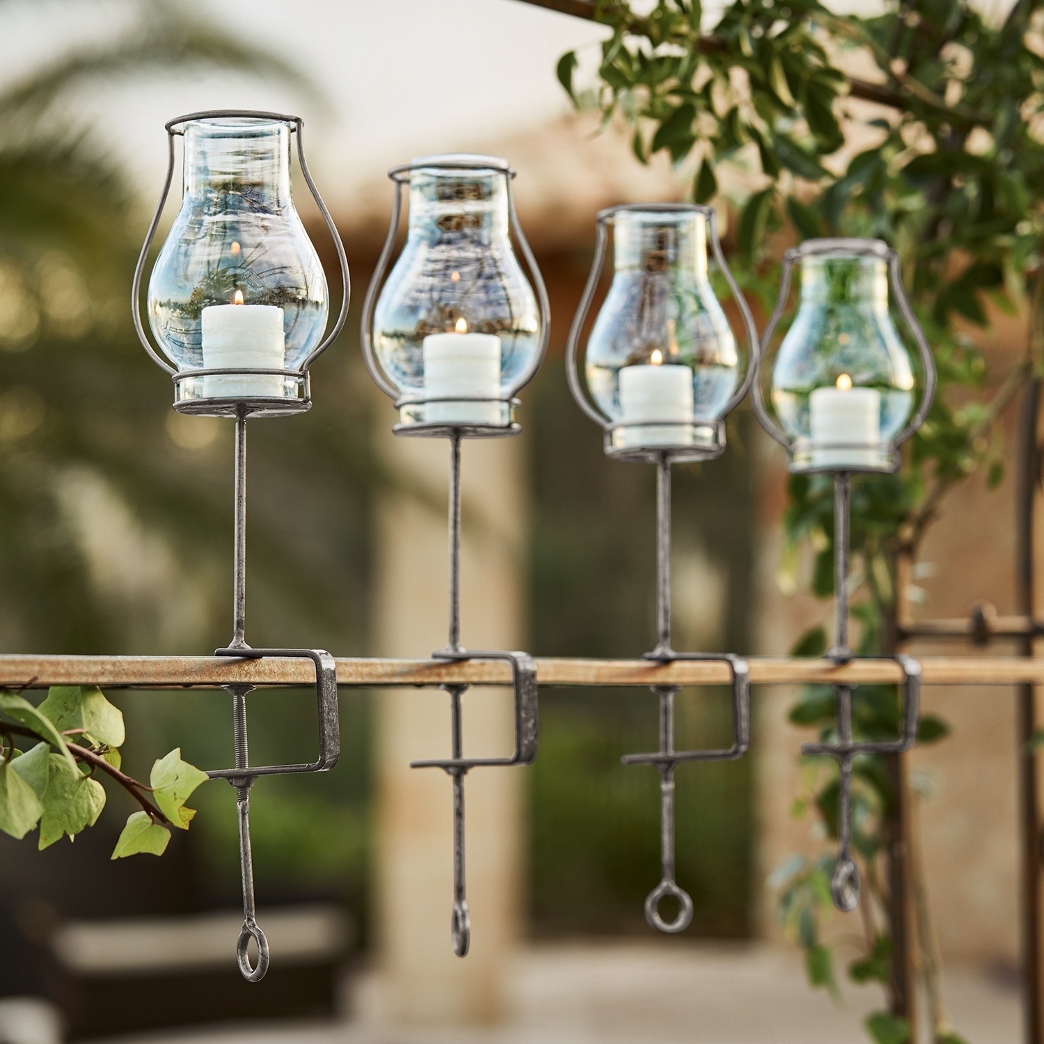 Set di 4 portacandele Calindra Set di quattro lanterne in vetro con supporti metallici per fissaggio a ringhiera, decorazione da giardino