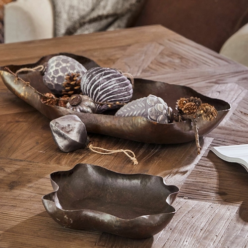 Ciotola e vassoio decorativi in metallo marrone su tavolo in legno in soggiorno