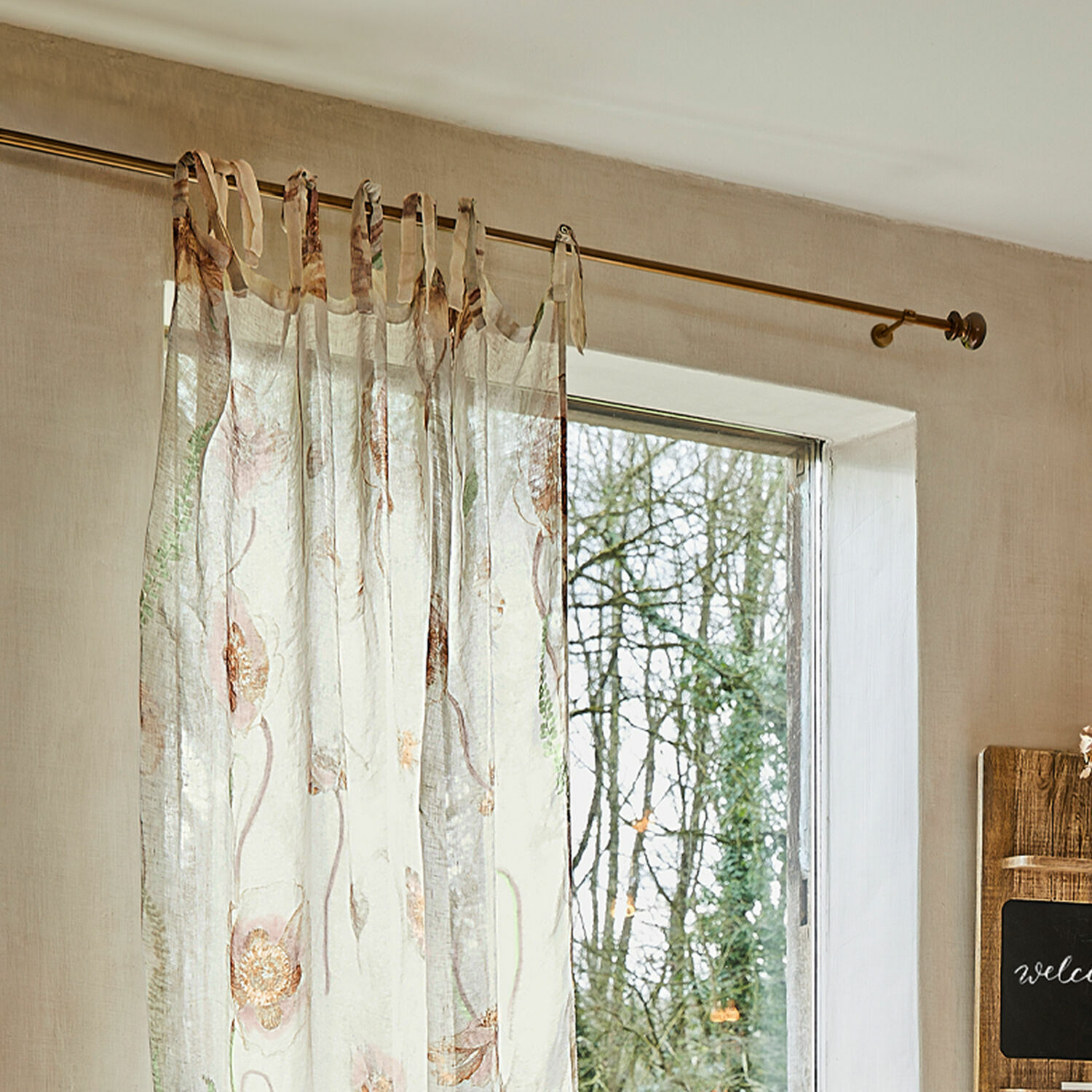 Bastone per tende Henderson Tenda trasparente con delicato motivo floreale in colori pastello appesa a bastone.