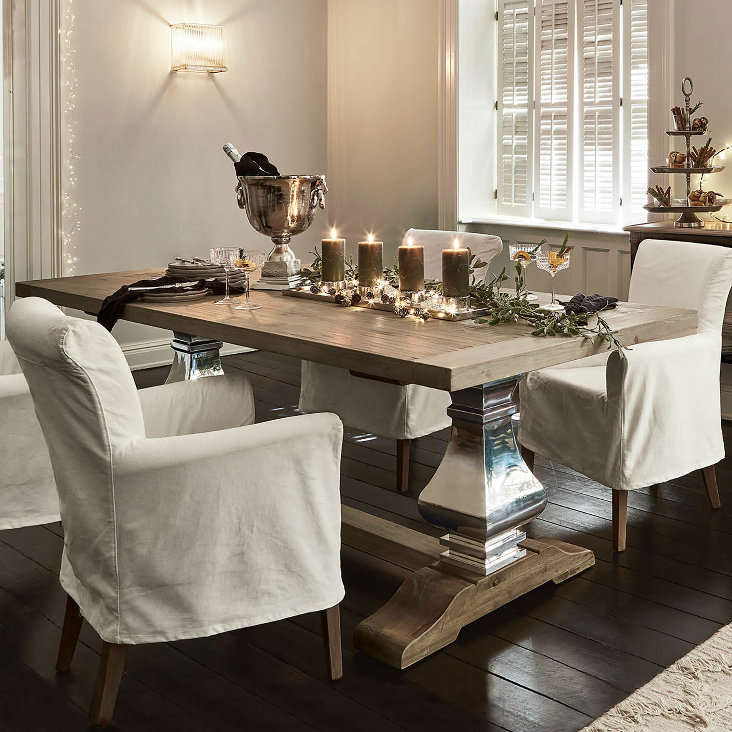Tavolo da pranzo Filton Tavolo da pranzo in legno chiaro con gambe in metallo e sedie con coperture bianche in interno elegante