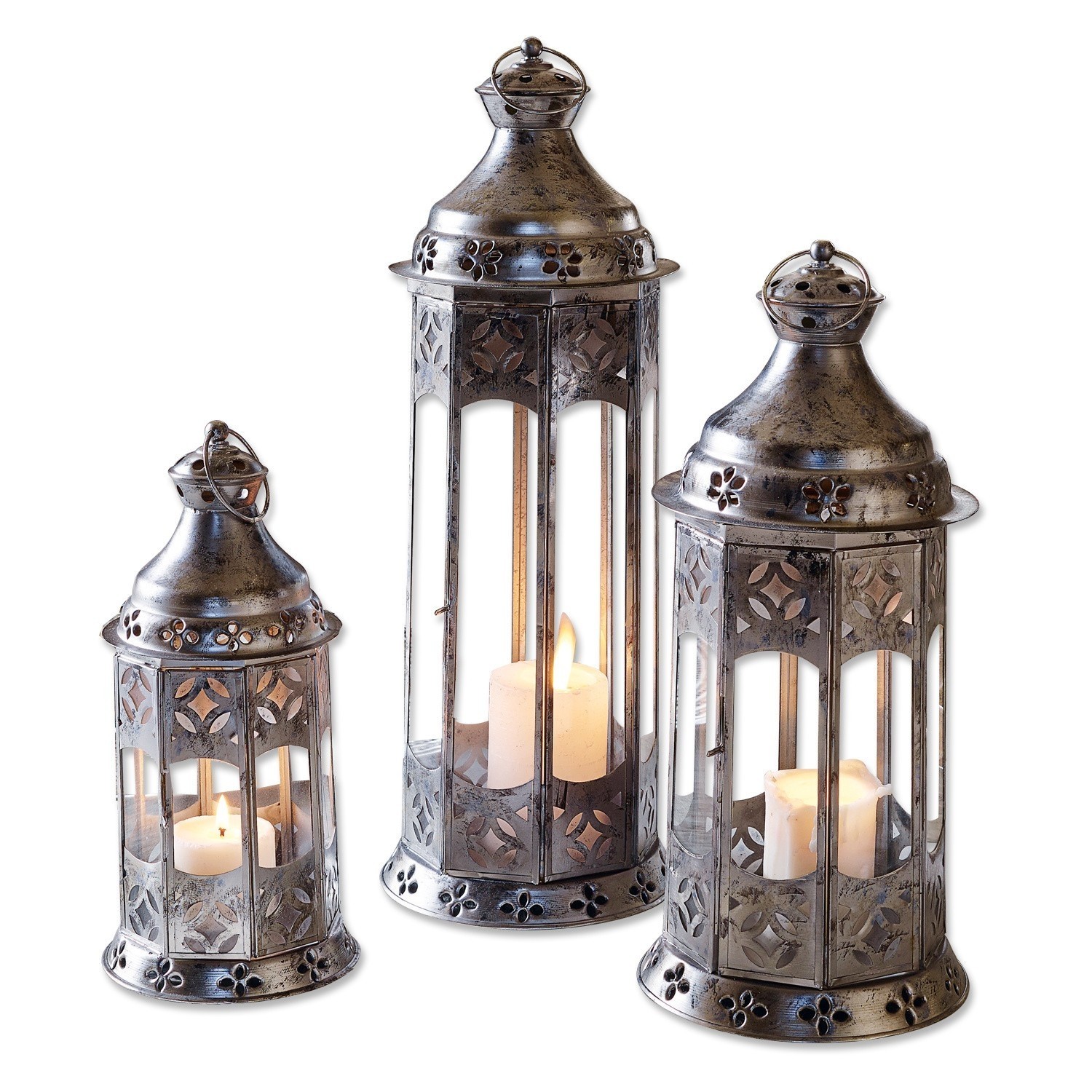 Set di 3 lanterne Aylin Set di tre lanterne in metallo color argento con motivi decorativi e candele accese all'interno
