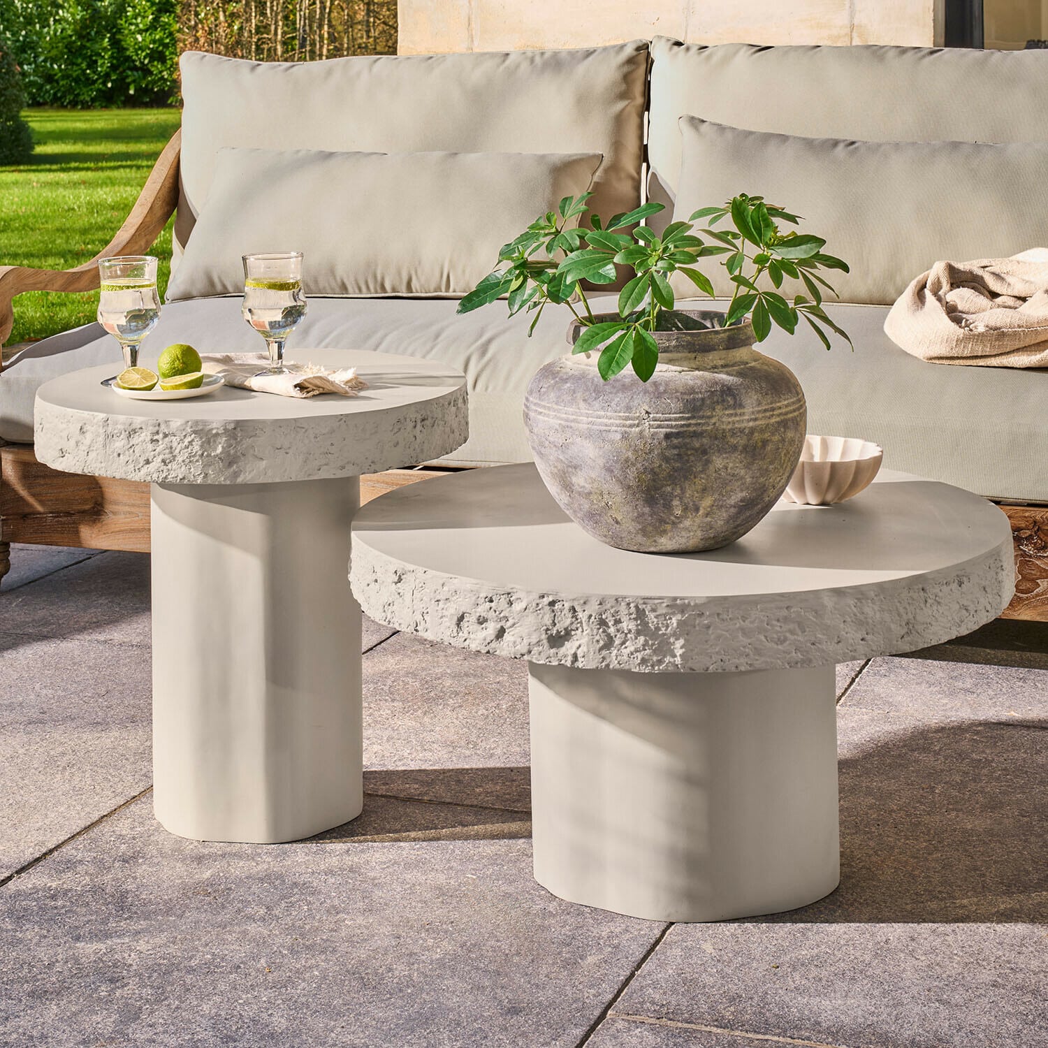 Tavolino da caffè per esterni Tivoliq Set di due tavolini rotondi in cemento grigio chiaro su terrazza con pianta e bevande