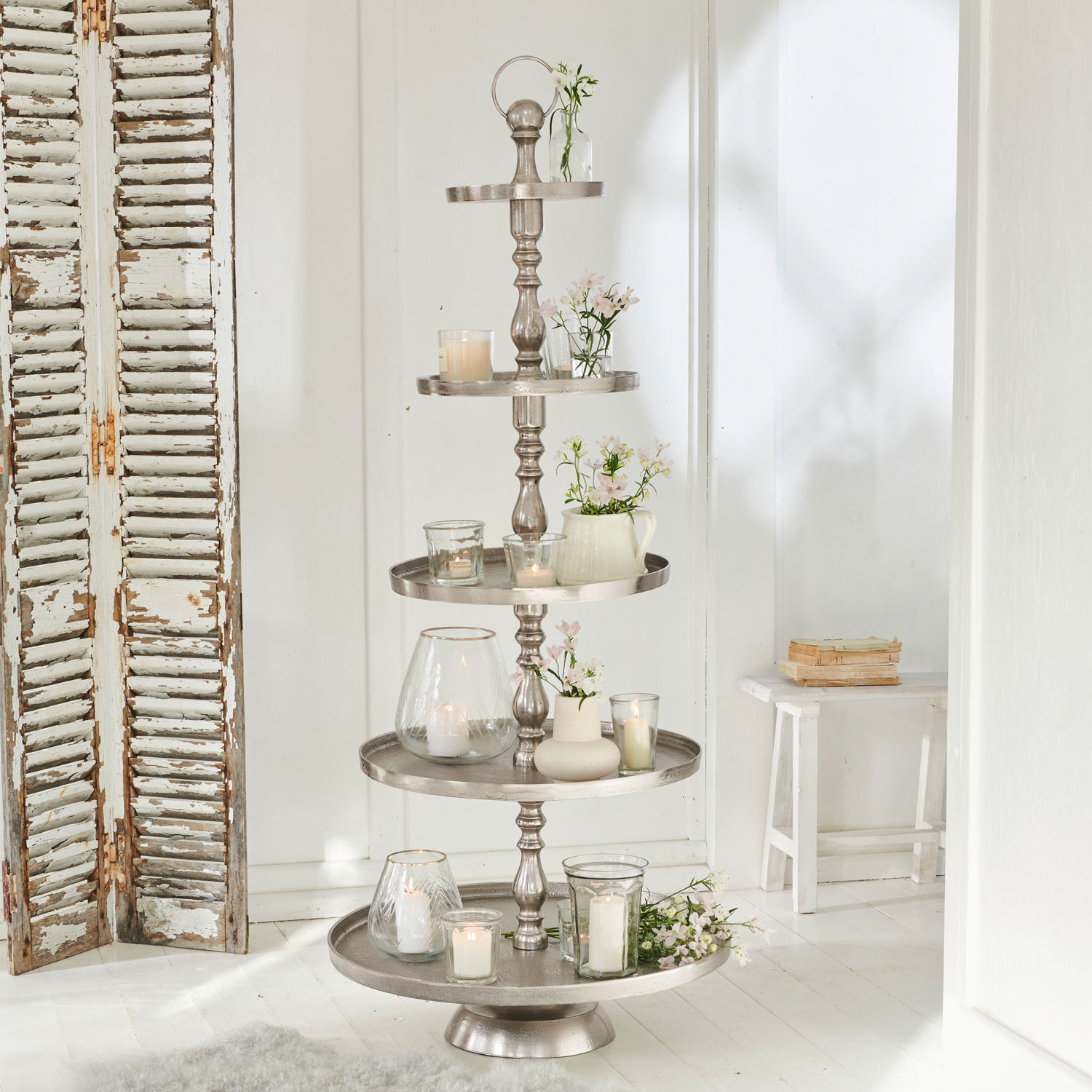 Alzata Magonie Portaoggetti decorativo in metallo argentato a cinque livelli con candele e fiori bianchi