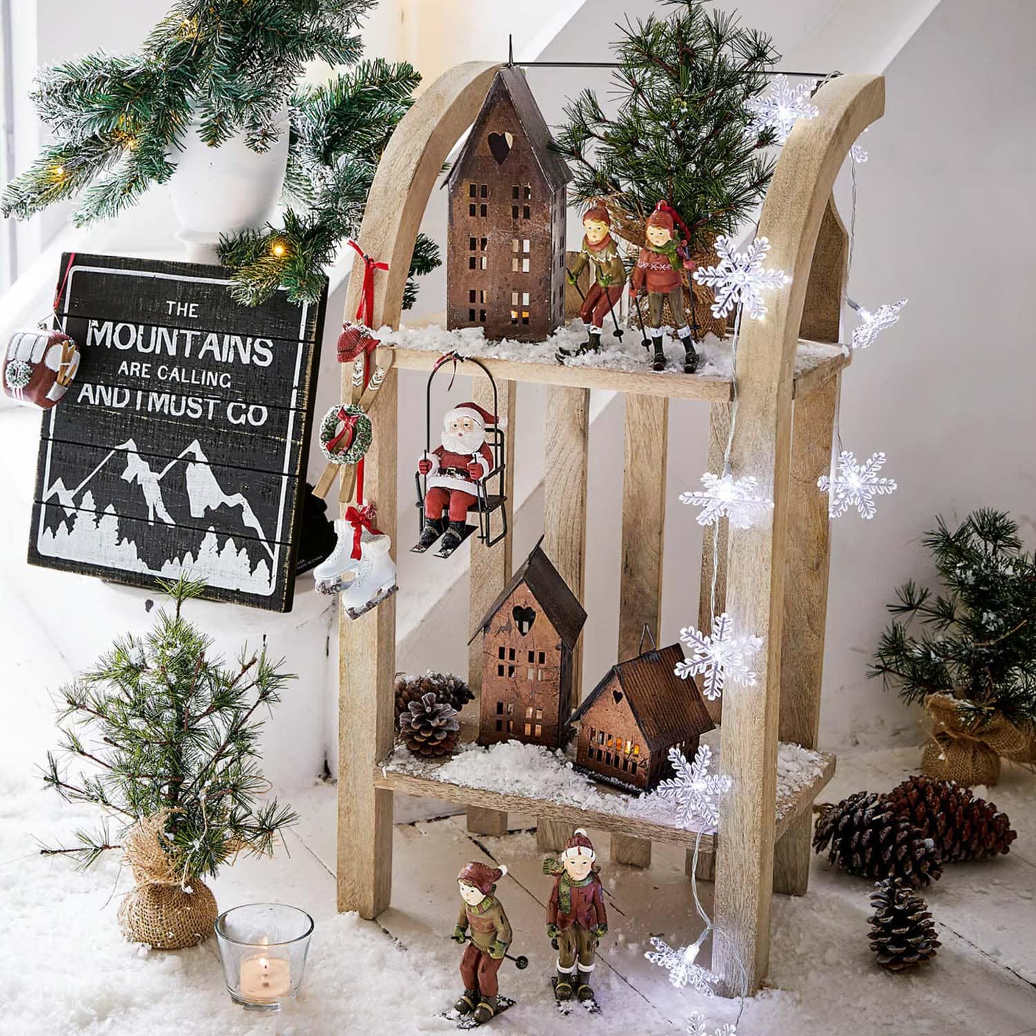 Decorazione natalizia in legno con figure di sciatori, Babbo Natale e casette su neve artificiale