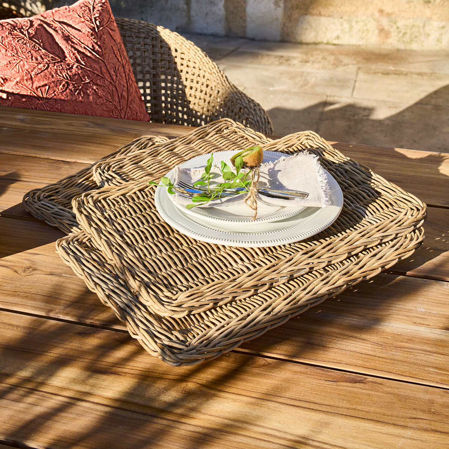 Set di 4 tovagliette Mossbury Set di tovagliette rettangolari in vimini naturale con piatto bianco e posate su tavolo in legno