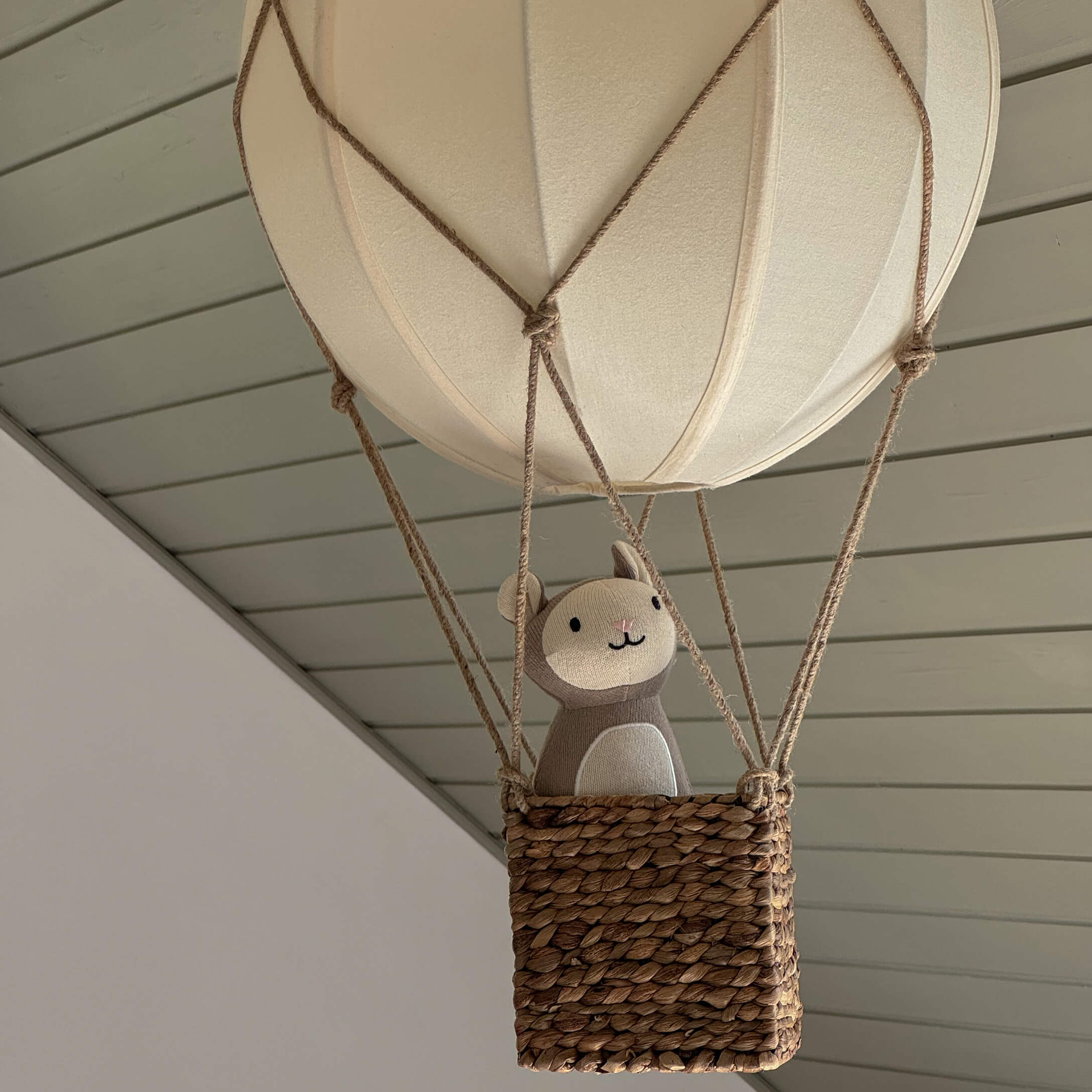 Pallone decorativo sospeso con cesta in vimini e peluche beige in tonalità neutre